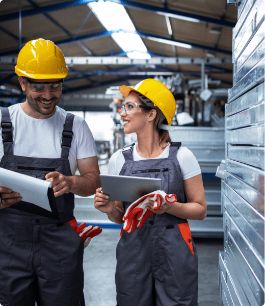 Factory workers walking through an industrial plant discussing production efficiency