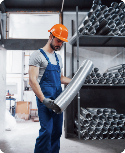 Portrait of a young worker in a hard hat at a large metalworking plant